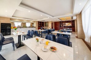 A hotel dining area with tables, chairs, and a buffet. - GeLi Hotel (Cenxi People's Hospital Bus Terminal) (Cenxi)