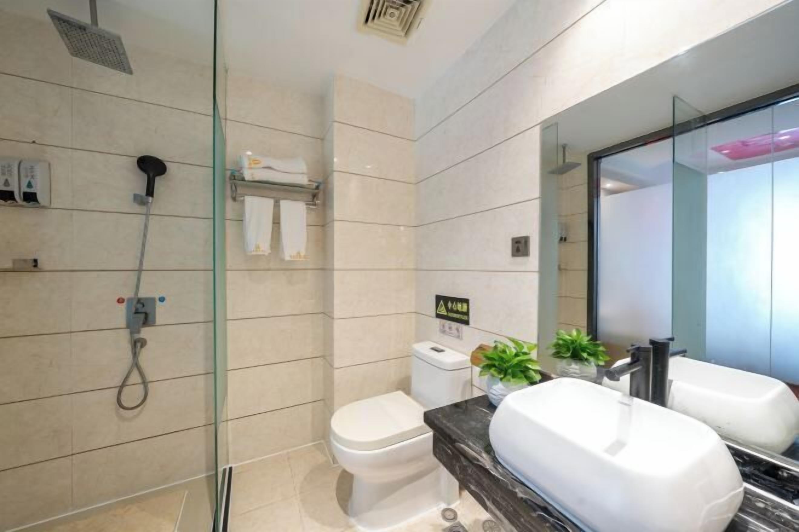 A modern bathroom with a glass shower enclosure, a toilet, and a vanity with two sinks.