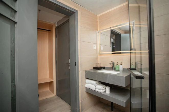 A modern bathroom with a glass shower enclosure, a built-in sink, and a mirror.