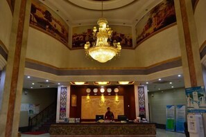 A lobby with a grand chandelier, a reception desk, and a mural on the wall. - Zhuhai Xinhong Hotel (Daxin Xinduhui Branch) (Zhuhai)