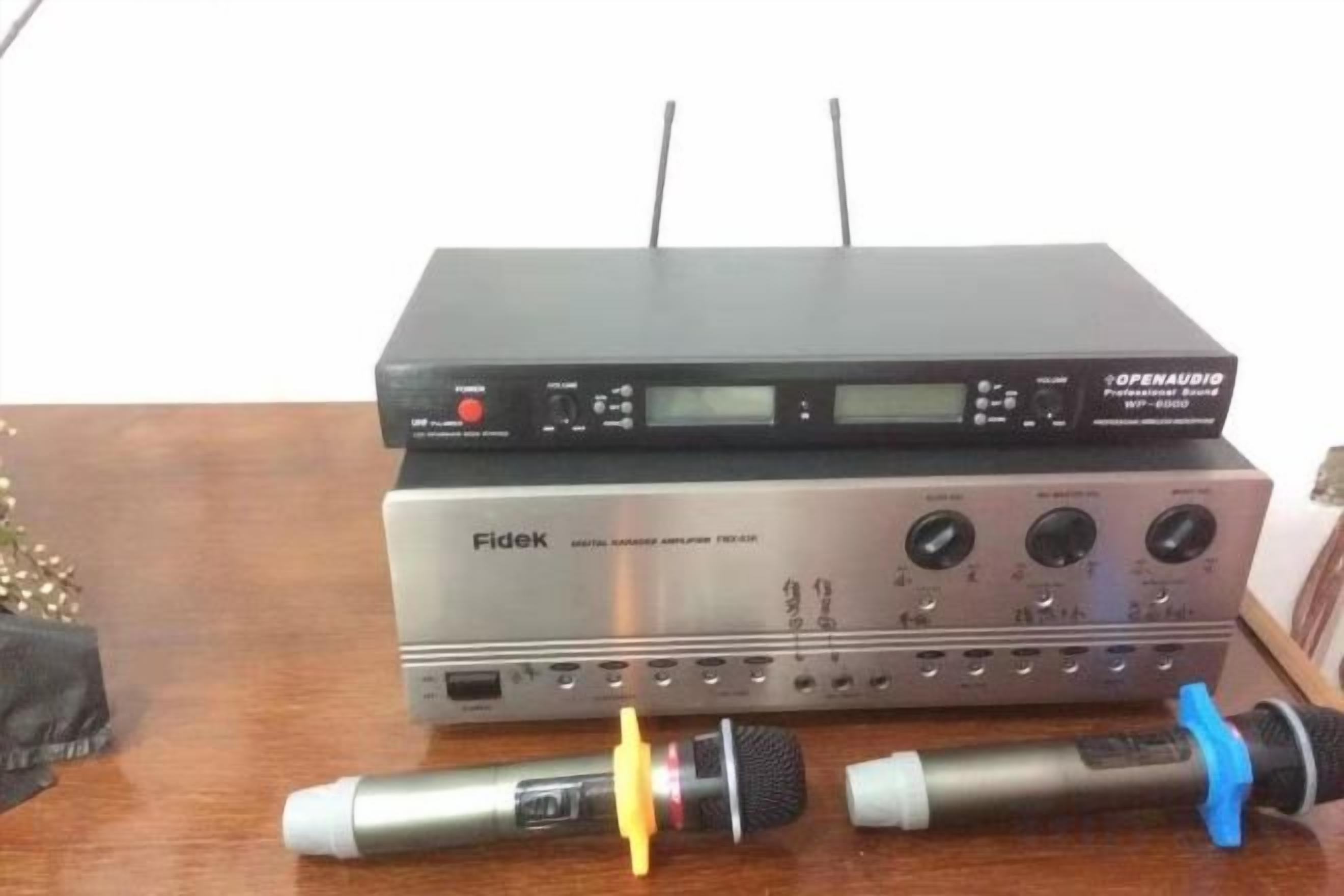 Une interface audio Fidek et un appareil OpenAudio sur une surface en bois.