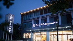 Un hotel amb un cartell ben visible que diu “白玉兰酒店” i “Blynton Classic”. 