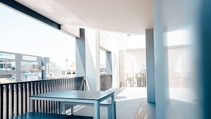 Un espacio al aire libre con mesa y bancos, con vistas a un paisaje urbano.