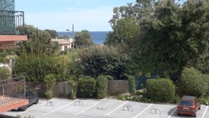 Un área de estacionamiento con vistas al mar y abundante vegetación.