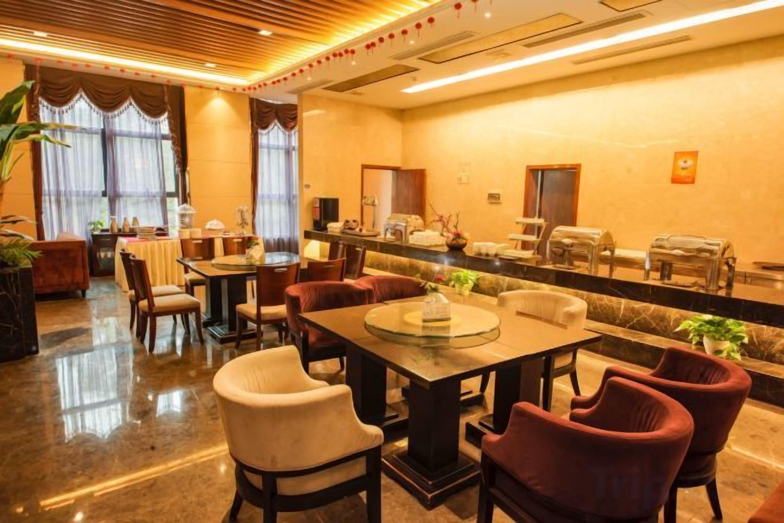 Un vestíbulo de hotel con mostrador de recepción, zona de estar y bufé.