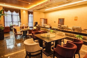 A hotel lobby with a reception desk, seating area, and a buffet. - Lijing Hotel (Ningbo)