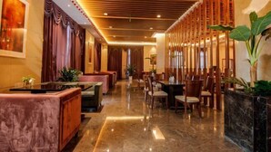 A hotel lobby with a polished marble floor, wooden panel ceiling, and a seating area with plush sofas and chairs. - Lijing Hotel (Ningbo)