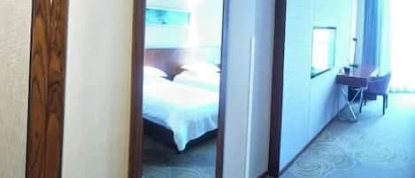Una habitación de hotel con una cama, un escritorio y una silla.