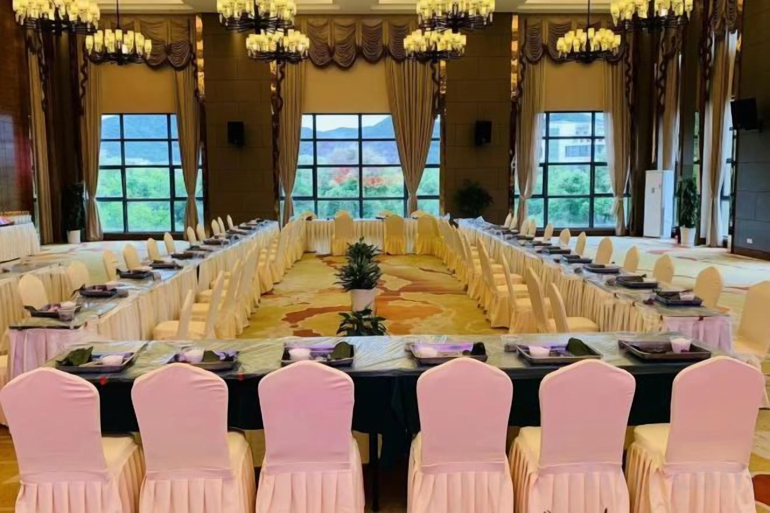 A conference room with a long table, chairs, and a chandelier.