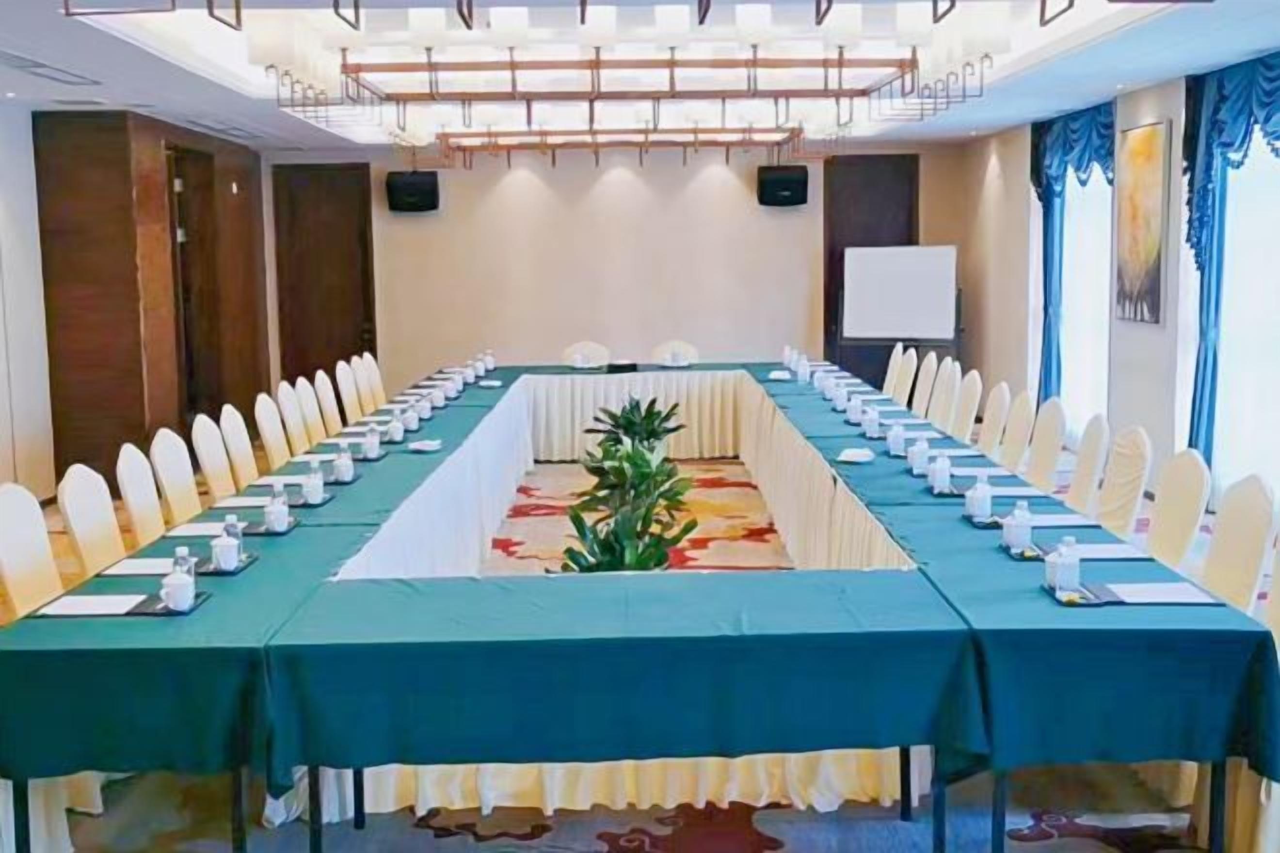 A conference room with a long table, chairs, and a whiteboard.