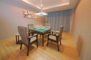 A dining area with a rectangular table, six chairs, and a green board game. - Lijing Hotel (Ningbo)