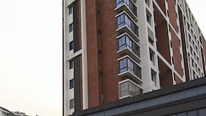 A multi-story building with a modern architectural design, featuring a combination of brick and glass elements. - Yaocheng Hotel (Shanghai)