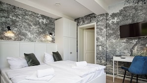 A bedroom with a large bed, a desk, and a TV. - Close to the beach, sauna + swimming pool free of charge - Strandresidenz Brandenburg FeWo 30 - House (Göhren)