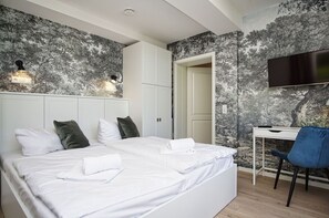 A bedroom with a large bed, a desk, and a TV. - Close to the beach, sauna + swimming pool free of charge - Strandresidenz Brandenburg FeWo 30 - House (Göhren)