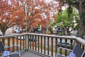 A residential area with autumn foliage, a street, parked cars, and houses.