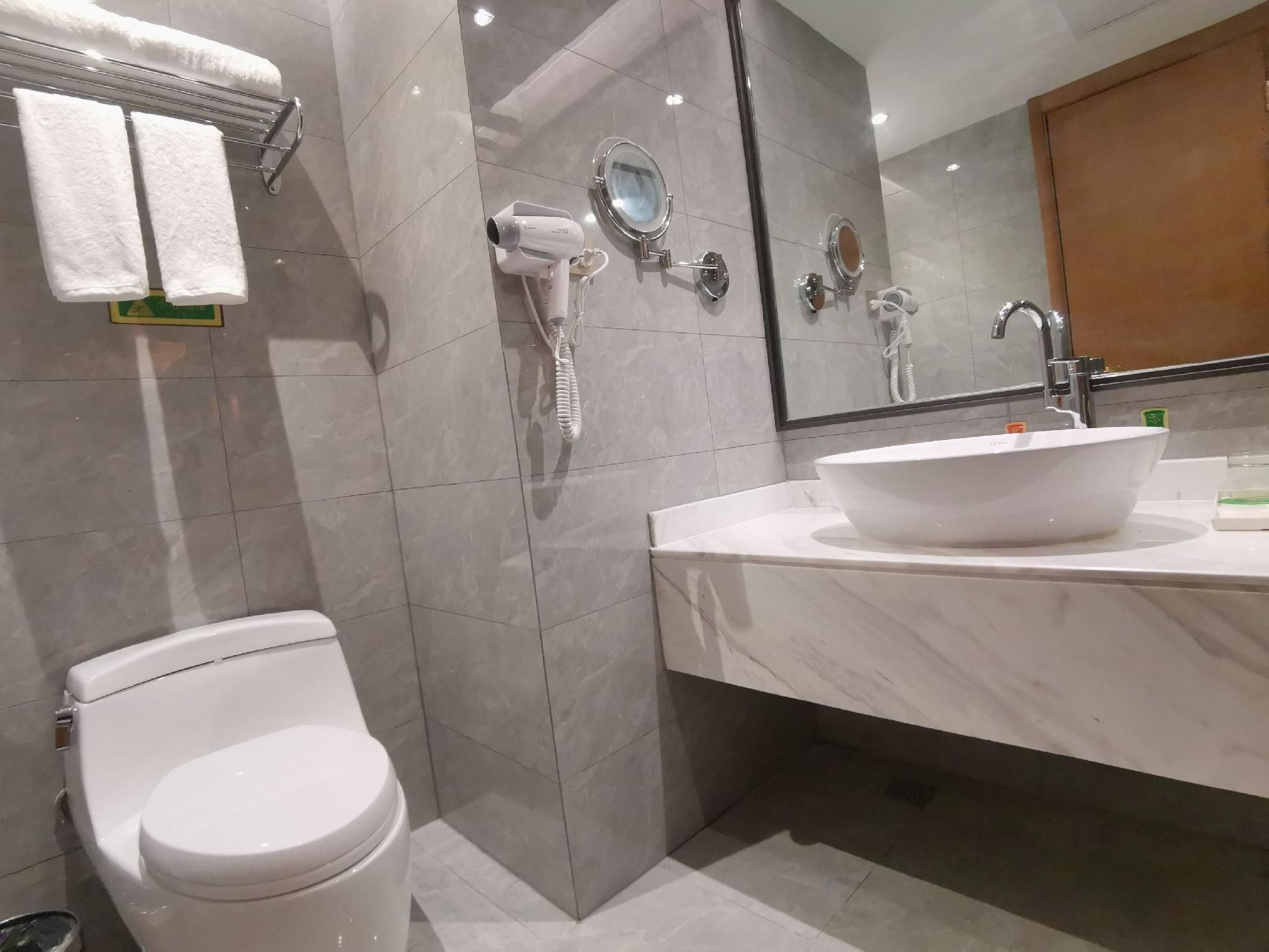 Ein modernes Badezimmer mit Toilette, Waschbecken und Spiegel.