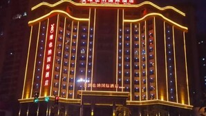 A hotel with multiple floors, illuminated by warm lighting, and featuring a prominent sign at the entrance. - Vienna International Hotel (Loudi Stadium) (Loudi)
