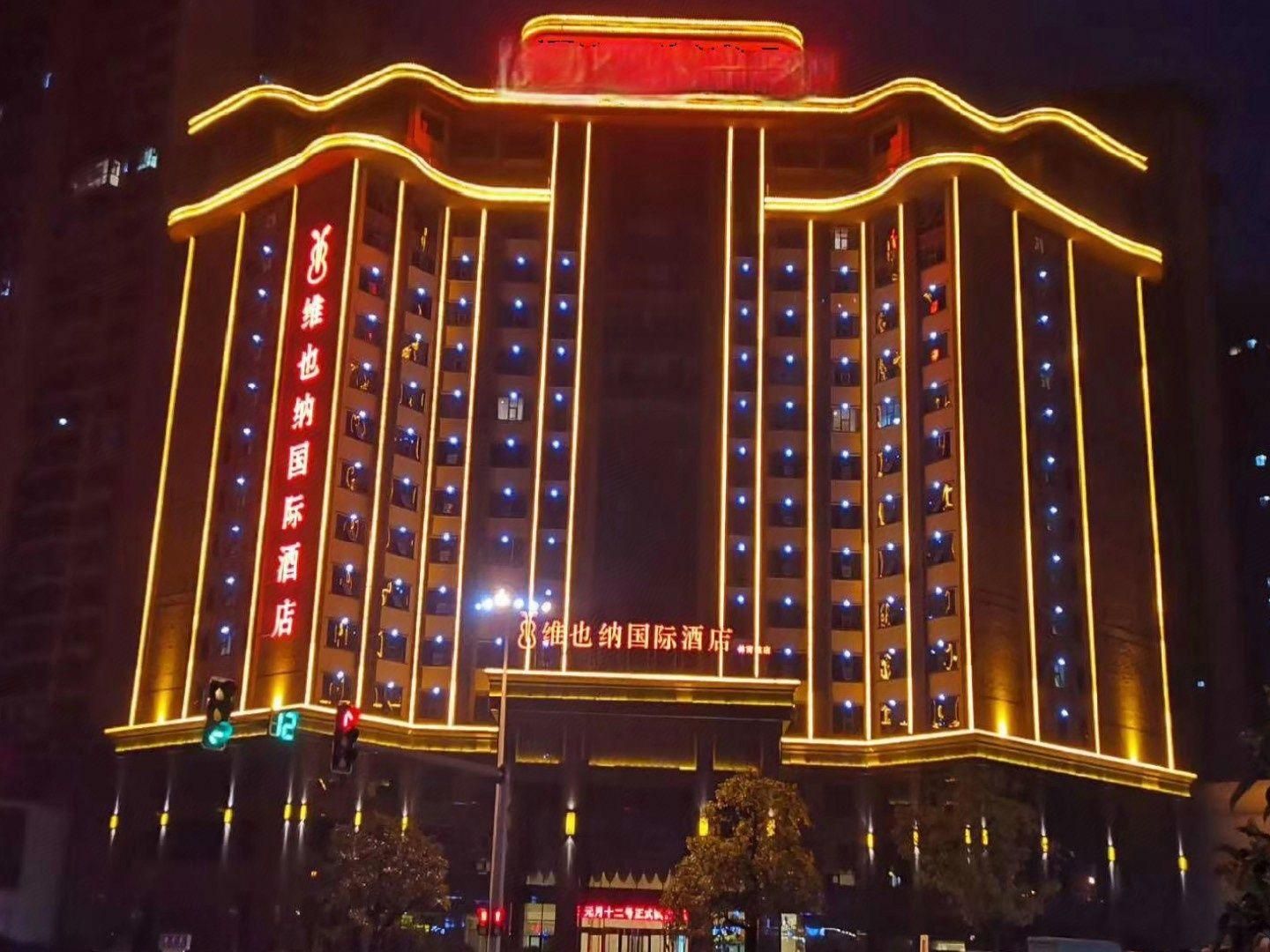 A multi-story hotel building with illuminated signage and a row of windows on each floor.