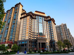 A multi-story hotel with a prominent entrance, large windows, and a modern architectural design. - Vienna International Hotel (Loudi)