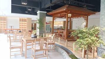A modern interior with wooden furniture, a central column, and a small indoor garden.