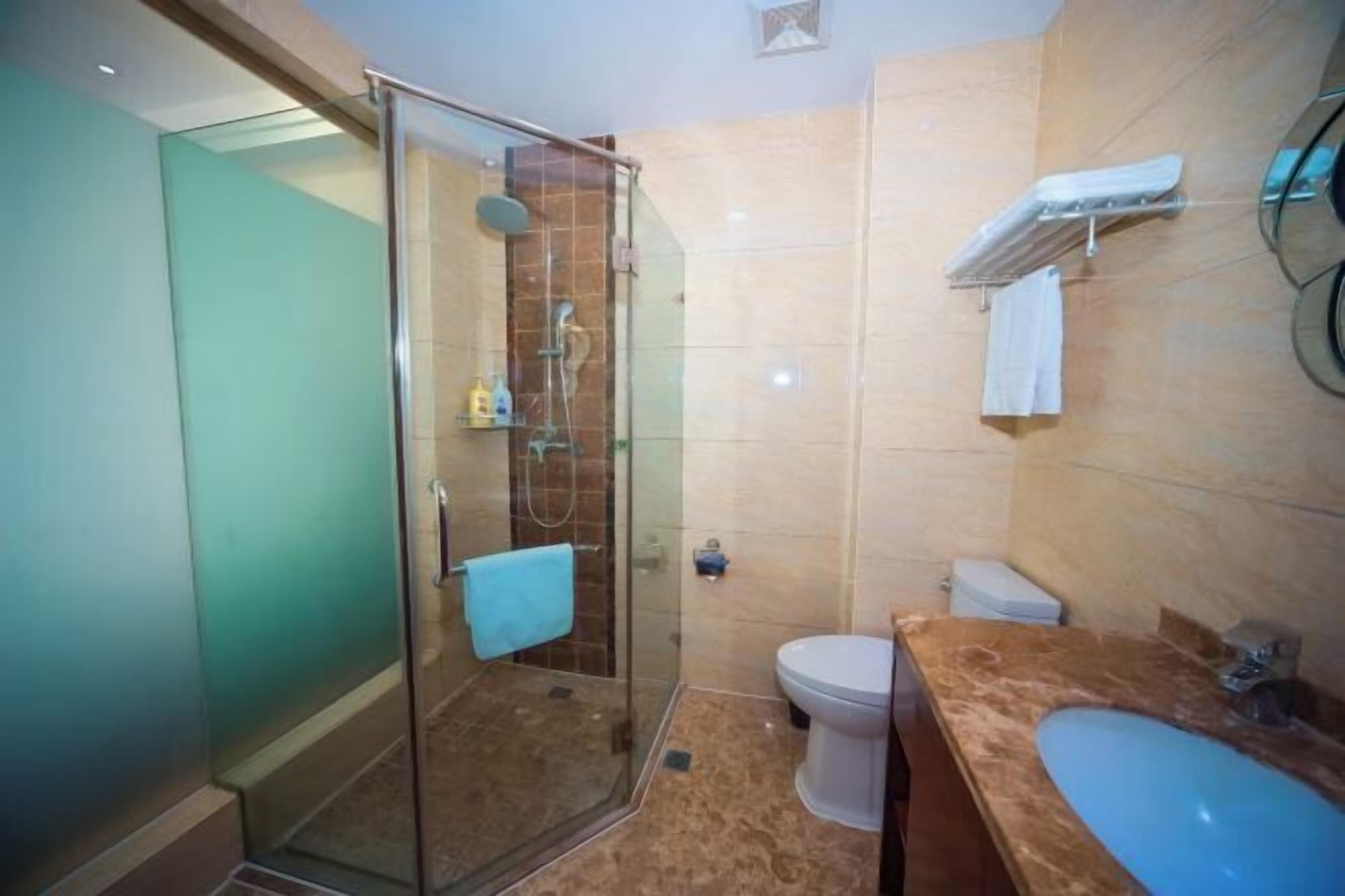 Un baño con ducha de vidrio, inodoro y lavamanos.