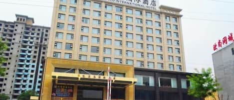 A multi-story hotel building with a prominent entrance and signage.