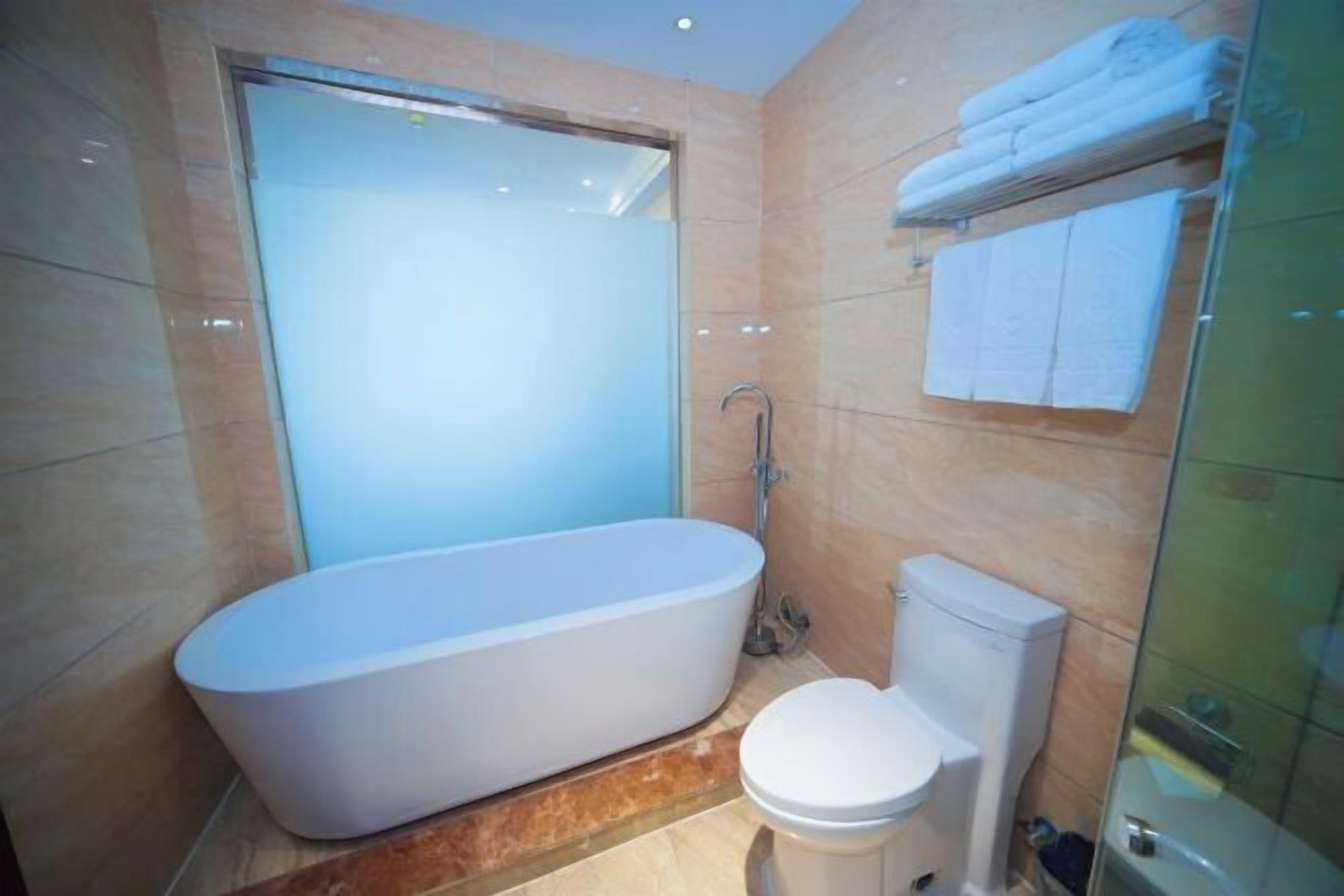 A modern bathroom with a freestanding bathtub, a toilet, and a glass shower enclosure.