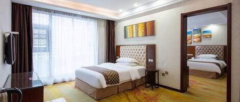 A modern hotel room with a large bed, a desk, and a view of the city.