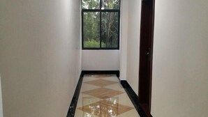 A hallway with a tiled floor and a window with a view of trees. - Guilin Guzhen Inn (Dawei Guzhen Inn) (Lingchuan)