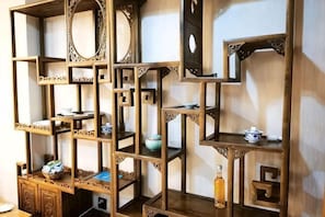 Un meuble d’étagères en bois à plusieurs niveaux, doté de différents compartiments et d’étagères, dont certains contiennent des objets décoratifs.