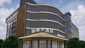 A modern hotel with a curved facade and large windows.