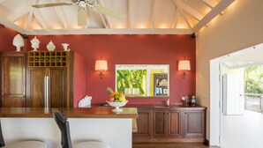 A kitchen with wooden cabinets, a central island with a fruit bowl, and pendant lighting.