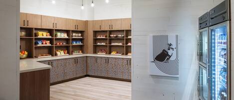 Cozinha moderna com armários de madeira, bancada preta e geladeira.