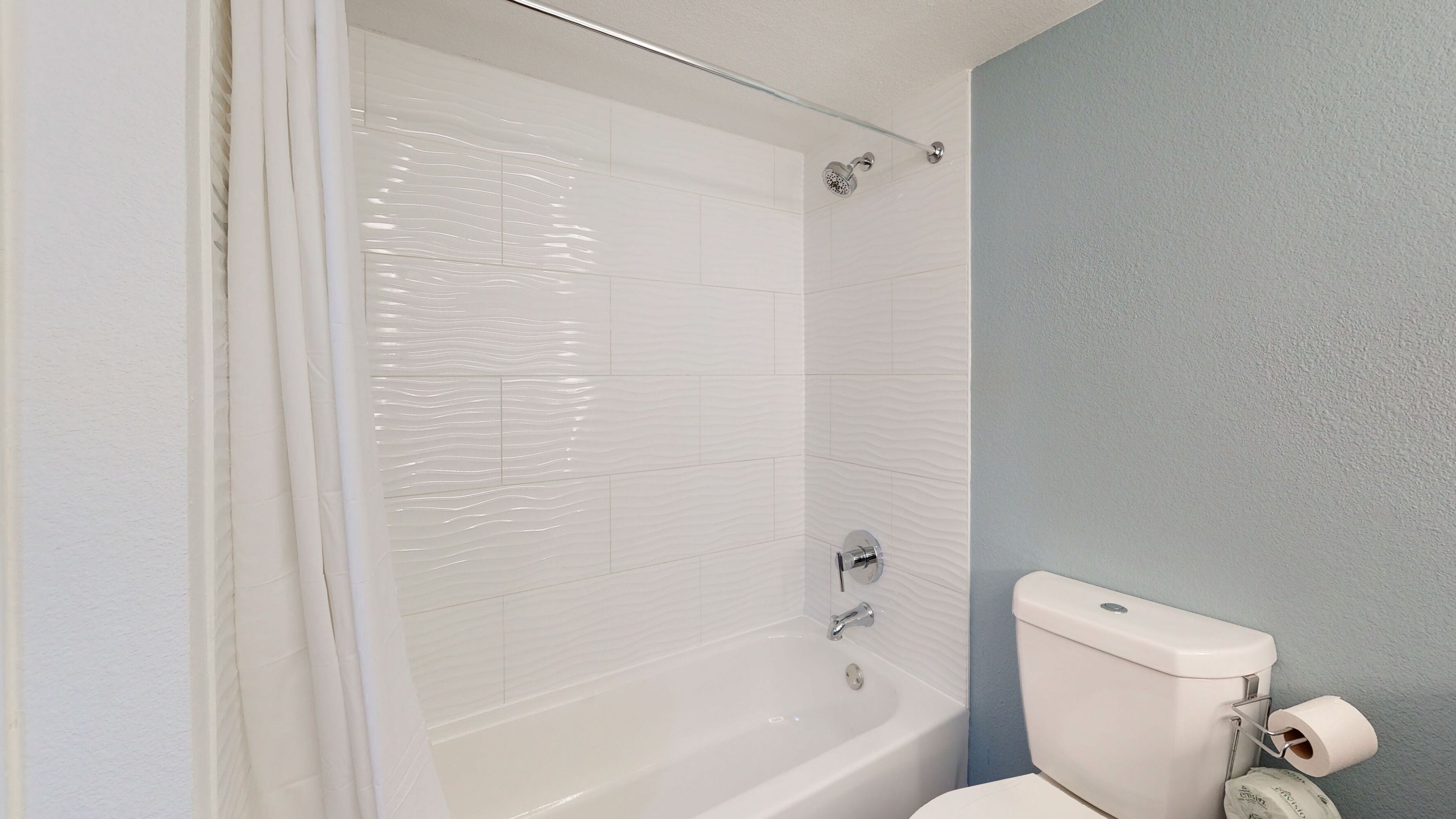 Une salle de bain avec une baignoire, des toilettes et un rideau de douche.