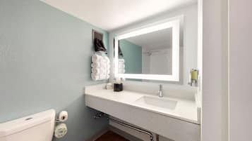 A bathroom with a white sink, a mirror, a towel rack, and a toilet.