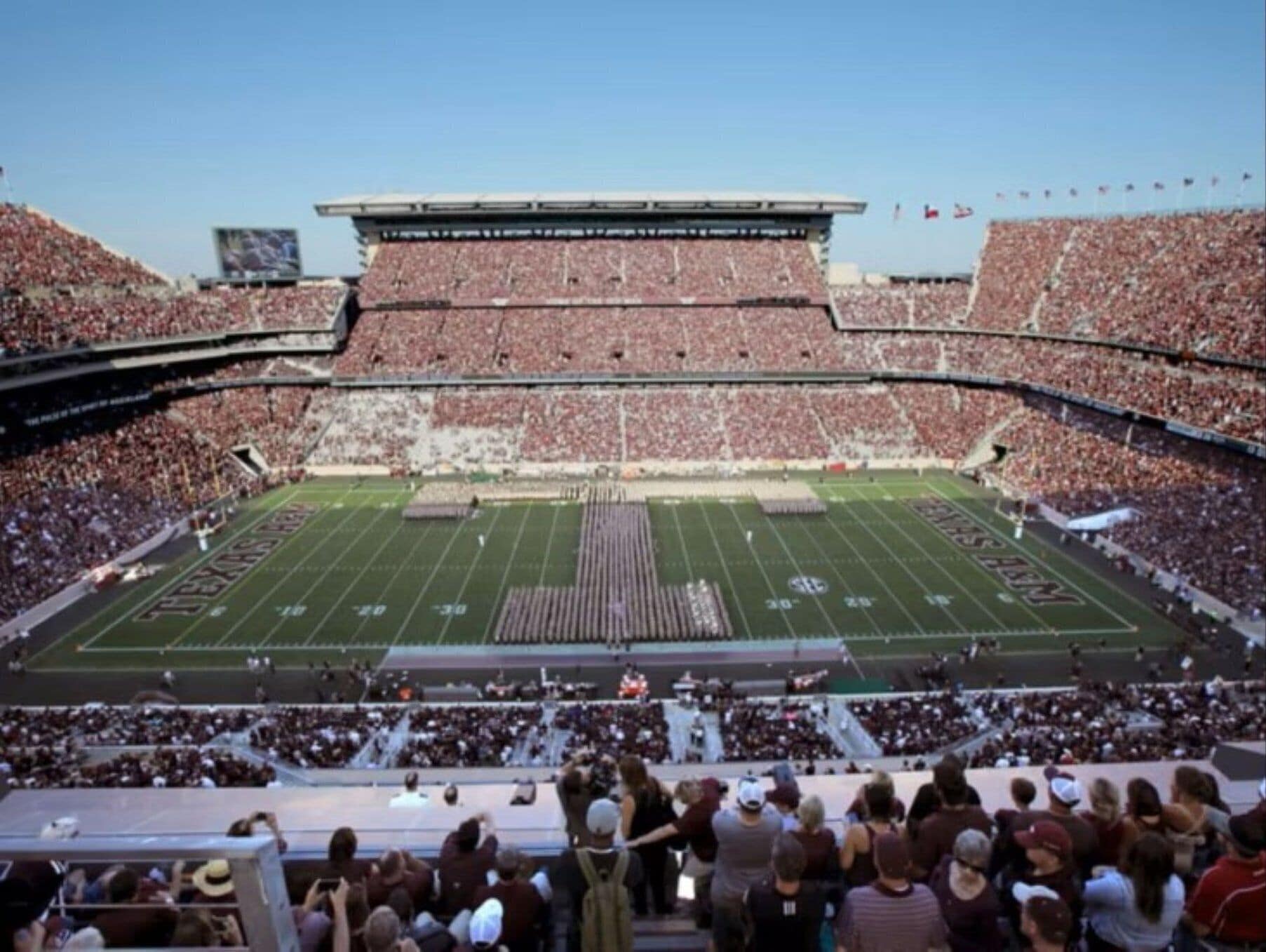 A large stadium with multiple tiers of seating and a football field.