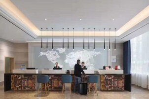 A reception area with a counter, bar stools, and a world map on the wall.