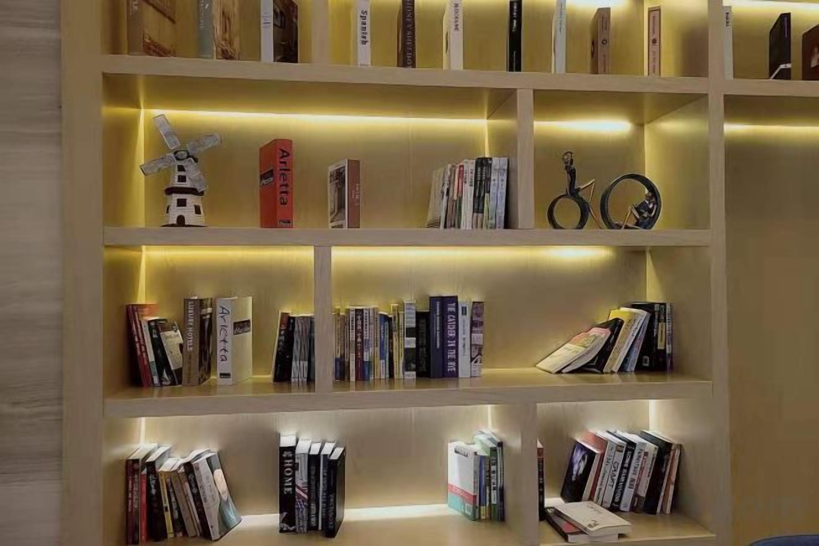 Una estantería con varios estantes, cada uno con libros y objetos decorativos.