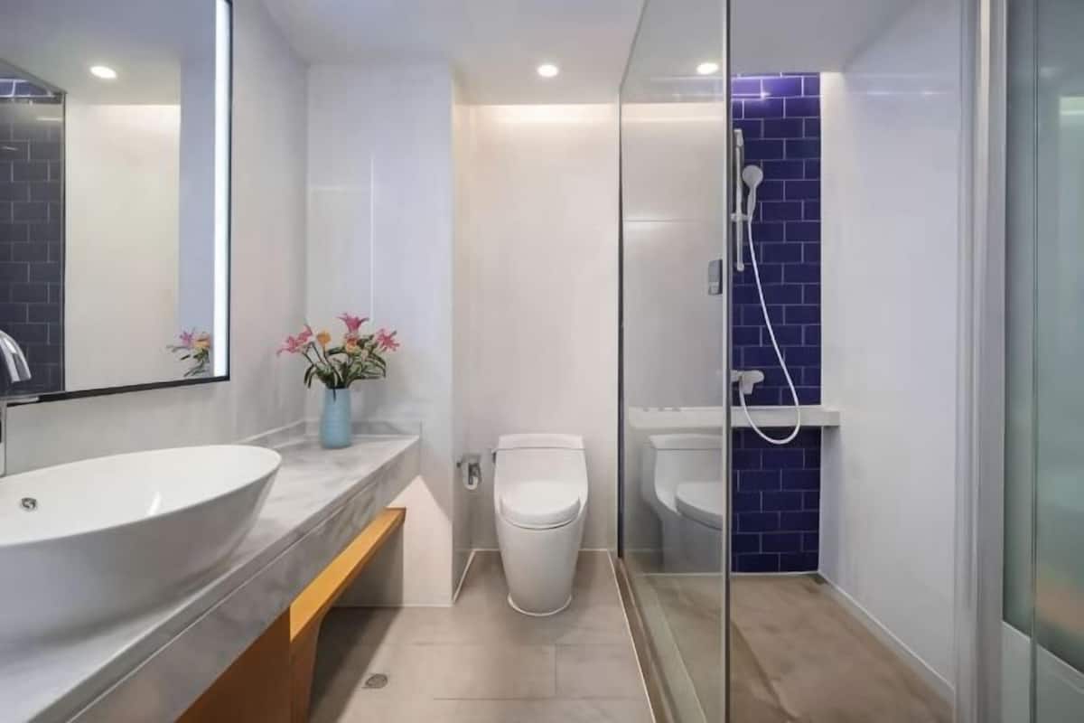 A modern bathroom with a large sink, toilet, and shower.