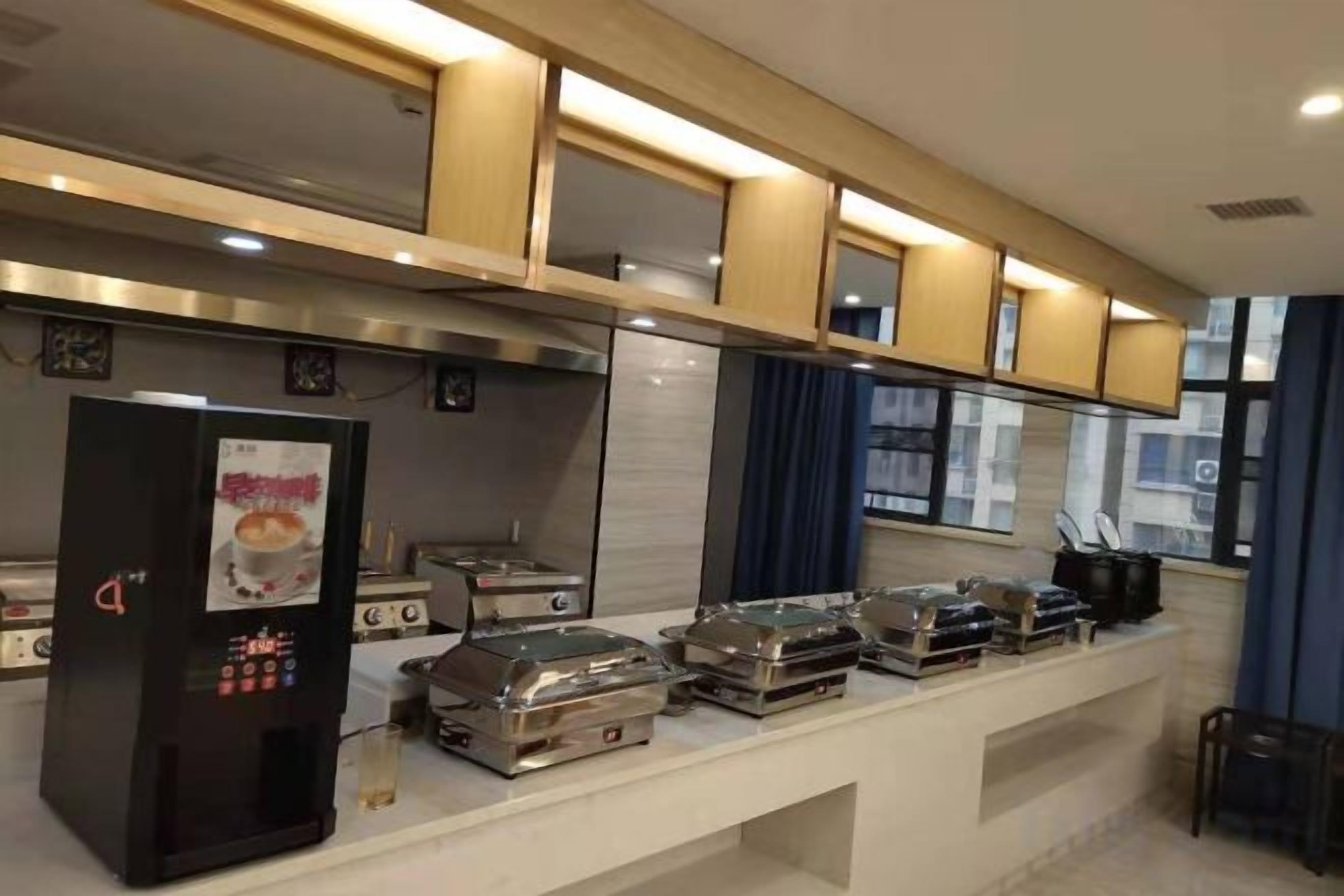 A modern kitchen with a built-in stove, a refrigerator, and a coffee machine.