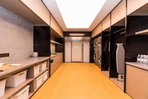A modern hotel corridor with a kitchen area on the left, a laundry room on the right, and a central door leading to another room. - Ji Hotel (Tianjin)
