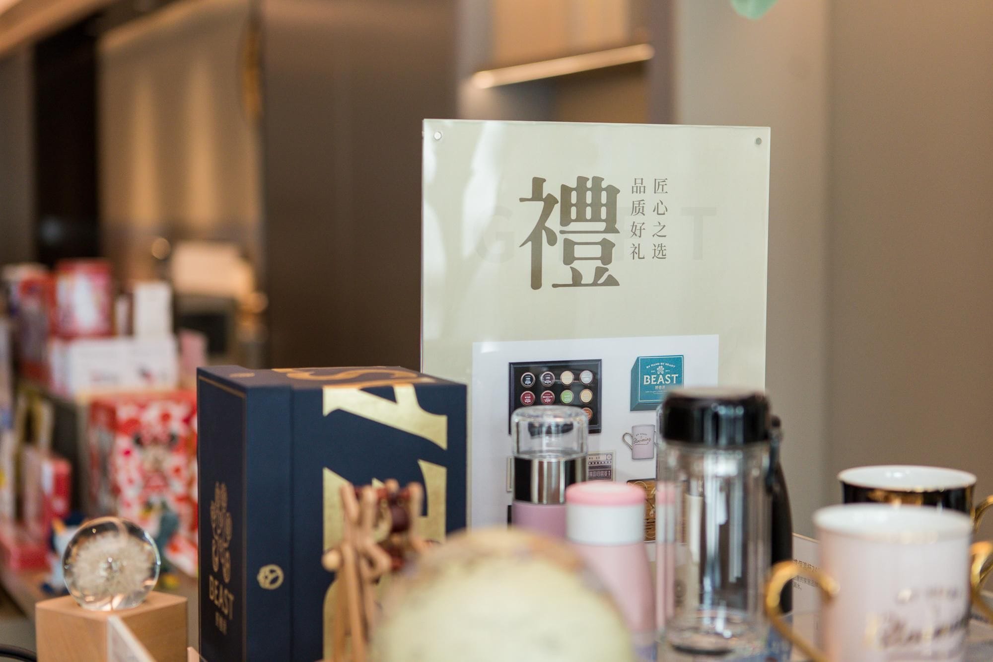 Exposição de itens relacionados a café, incluindo uma máquina de café, uma xícara e uma caixa com texto em japonês.