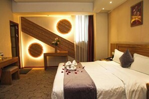A hotel room with a bed, a desk, and a wall-mounted clock. - Very Huating Hotel (Chongqing)