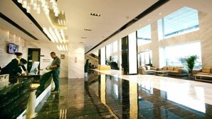 A modern hotel lobby with a marble reception desk, seating area, and large windows. - Mellow Crystal Hotel (Zhangjiajie)