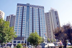 A high-rise hotel with multiple floors, large windows, and a prominent sign at the top. - Mellow Crystal Hotel (Zhangjiajie)