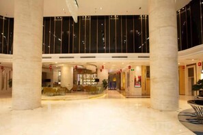 A spacious lobby with a high ceiling, large columns, and a glass railing overlooking the area. - Haowangjiao Hotel (Gutian)