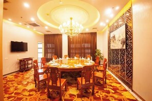 A conference room with a round table, chairs, a chandelier, and a patterned wall. - Haowangjiao Hotel (Gutian)