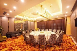 A conference room with a round table, patterned chairs, and a chandelier. - Haowangjiao Hotel (Gutian)