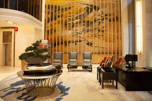 A lobby with a reception desk, seating area, and a large abstract wall mural.