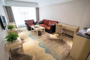 Una sala de estar moderna con un sofá, una mesa de centro y un escritorio pequeño.